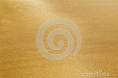 Texture of sand. Golden sand. Wet sand glitters on bright sun Stock Photo