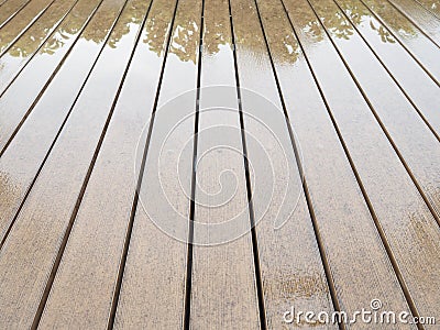 Texture of vintage lath wood plank panel floor wet from rain with reflection of tree Stock Photo
