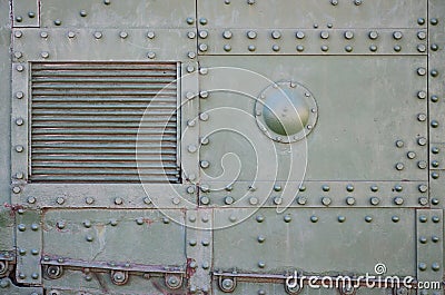 The texture of the wall of the tank, made of metal and reinforced with a multitude of bolts and rivets. Images of the covering of Stock Photo