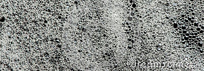 Texture of white foam on a black background. Cleansing mousse for the face or shaving foam or washing powder. Closeup Stock Photo