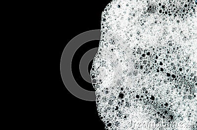 Texture of white foam on a black background. Cleansing mousse for the face or shaving foam or washing powder. Isolated Stock Photo