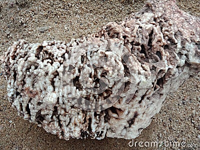 Textured crystal stone on the sand, rare semiprecious. textured background. Stock Photo