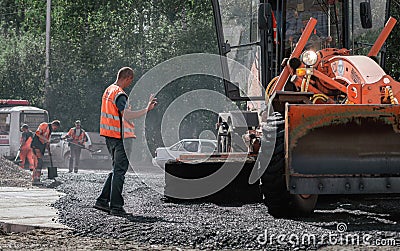 30th of August, Russia, Tomsk, road workers repair roadbed Editorial Stock Photo