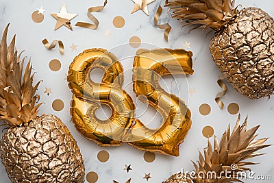 85th birthday celebration card with gold foil balloons and golden pineapples Stock Photo