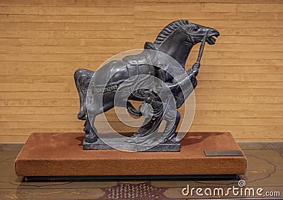 19th century black stone statue of a Chinese horse and handler on public display in a resort on Maui. Editorial Stock Photo