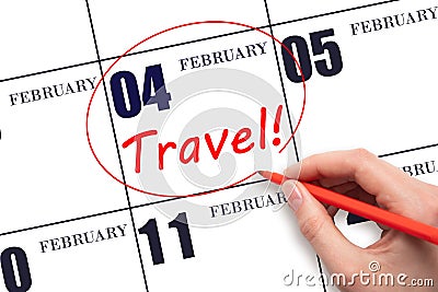 Hand drawing a red circle and writing the text TRAVEL on the calendar date 4 February. Travel planning. Stock Photo