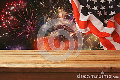 4th of July background. Wooden table over fireworks and USA flag. Independence day celebration Stock Photo