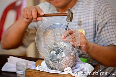 Thai artisan carves floral design onto silver pot Stock Photo