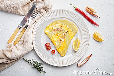 Thai Asian omelette, fresh red chilli, brown and white crabmeat, lemon, Cheddar cheese, eggs, on plate, on white background, top Stock Photo