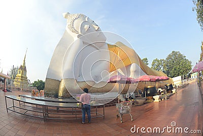 Thai Buddhists Paste gold leaf on the largest Reclining Buddha. Editorial Stock Photo