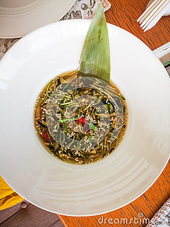 Thai cold soup with cucumber, eggplant and chuka, seaweed and sesame on a white plate Stock Photo