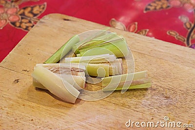 Thai cooking: Pounding, chopping fresh lemongrass on wooden cutting board Stock Photo
