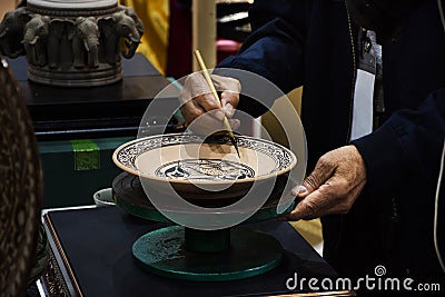 Thai craftsmanship technician or professional ceramicist drawing and painting color on handmade ceramic pottery and handicraft Stock Photo