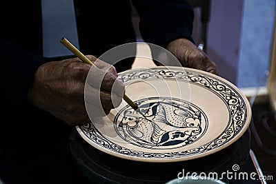 Thai craftsmanship technician or professional ceramicist drawing and painting color on handmade ceramic pottery and handicraft Stock Photo