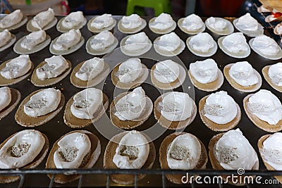 Thai desserts are made from batter, filled with white cream filling on top. Placed on a beautiful stainless steel wire Stock Photo