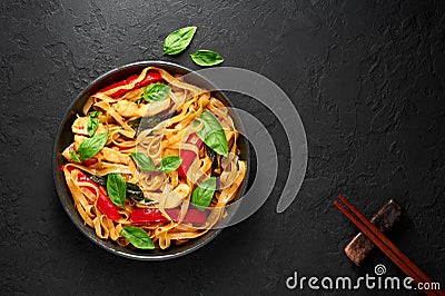 Thai Drunken Noodles or Pad Kee Mao in white plate at black slate background. Drunken Noodles is thai cuisine dish Stock Photo