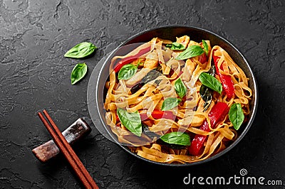Thai Drunken Noodles or Pad Kee Mao in white plate at black slate background. Drunken Noodles is thai cuisine dish Stock Photo