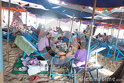 Thai family eating lunch seated at beach Editorial Stock Photo