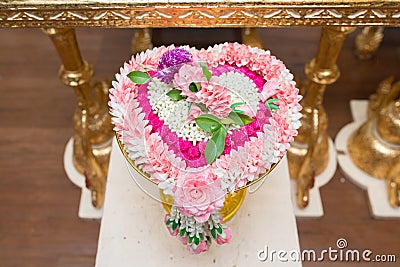 Thai flower heart shaped garland on golden tray with pedestal use for blessed water in Thai wedding ceremony Stock Photo