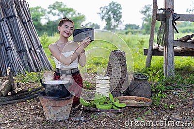 Thai lady beautiful dressing traditional northern style listening radio music from transistor a have happy joyful smiling in rice Stock Photo
