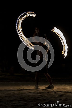 Thai man fire juggling at night on a beach of Koh Lipe island in Thailand Stock Photo