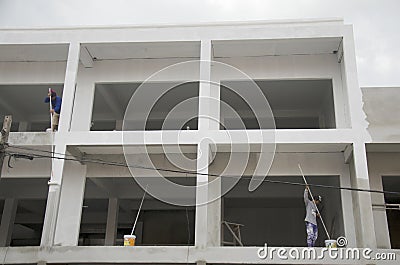 Thai man painting white color on building at construction site i Editorial Stock Photo