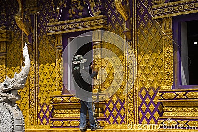 Thai man worker people and profesional builder working renovate build church and spray painting gold color ubosot or ordination Editorial Stock Photo