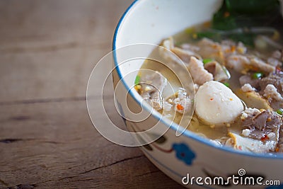 Thai noodle soup,Tom Yum in bowl on wooden background with copy space. Stock Photo