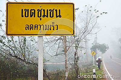 Thai people carrying sack walking at beside road with traffic sign Editorial Stock Photo