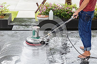 Thai people cleaning black granite floor with machine and chemical Stock Photo