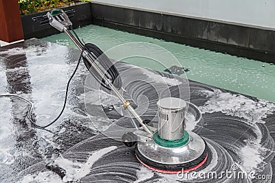 Thai people cleaning black granite floor with machine and chemical Stock Photo