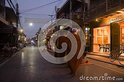 Thai people put food offerings to monks procession walk on the road Editorial Stock Photo