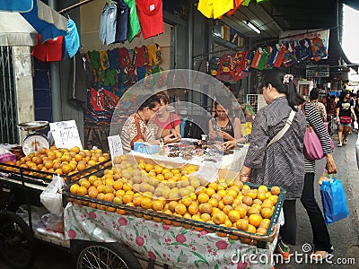 Thai people shopping for fruits and bracelet at the market Editorial Stock Photo