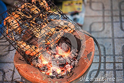 Thai river prawns grilled over charcoal grill Grilled on a BBQ Thai iron grill . Giant grilled lobster cook on charcoal stove at T Stock Photo