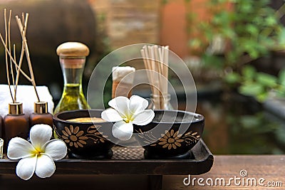 Thai spa composition treatments aroma therapy with candles and Plumeria flowers on wooden table close up. Stock Photo