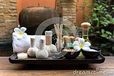 Thai spa composition treatments aroma therapy with candles and Plumeria flowers on wooden table close up. Stock Photo