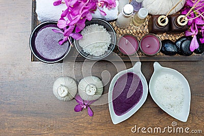 Thai Spa Treatments aroma therapy salt and nature sugar scrub and rock massage with orchid flower on wooden with candle. Thailand. Stock Photo