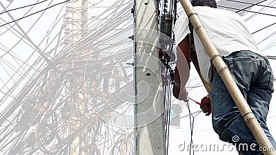 Thai Technician working at electricity pole Stock Photo