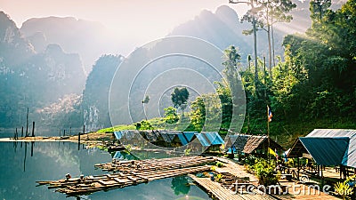 Thai village on the lake. Huts on the water under the sun. Rafts on the pier. Stock Photo