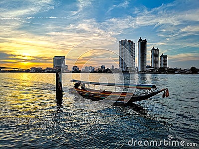 Thai water transportation, boat on ChawPhaya river cruise passing buildings in the evening Editorial Stock Photo