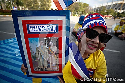 Thai woman with a photo of King Rama X and Queen Suthida Editorial Stock Photo