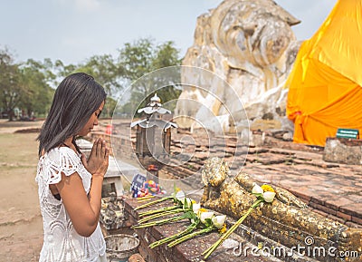 Thai woman praying in Ayutthaya temple in front the big buddha. Stock Photo