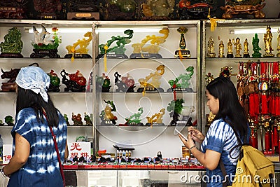 Thai women select and buy holy amulet and jade accessory form talismans souvenir shop of Kaiyuan Temple at Teochew in Guangdong Editorial Stock Photo