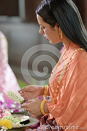 Thai women in Thai traditional dress are decorating flowers Stock Photo