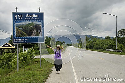 Thai women traveler posing for take photo with distance sign guide pole Editorial Stock Photo