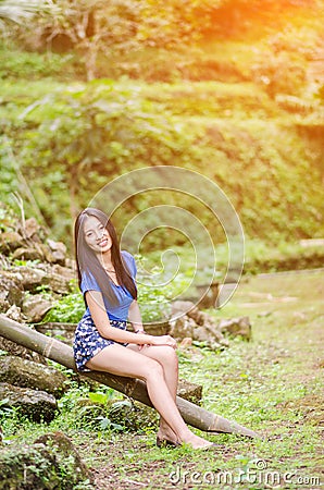 Asian girl sit down path in Bamboo forest Stock Photo