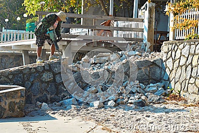 Thailand. Hua hin. January 2020. Repair work on beach. Worker with a jackhammer. Device is hollow stone. Jackhammer for rock. Editorial Stock Photo