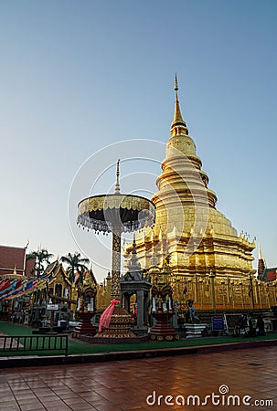 golden Haripunchai Pagoda in temple, the famous destination and tourist attraction in the North of Thailand with sunset sky in win Editorial Stock Photo