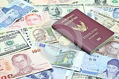 Thailand passport on mixed currency banknotes Stock Photo