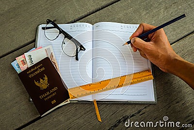 Thailand passport with money, yellow ruler, hand with pencil Stock Photo